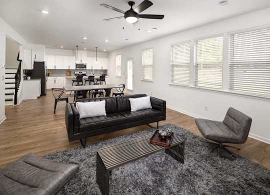 Living room with large couch, accent chairs, and windows.