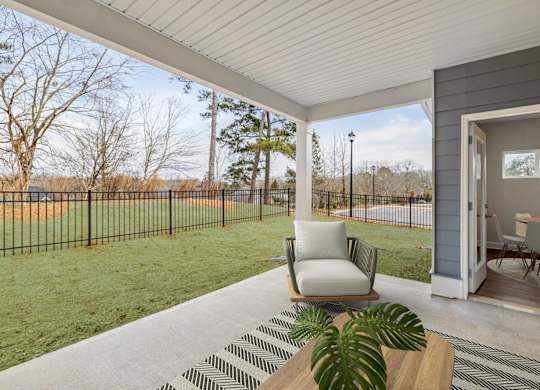A patio with a chair and a table with a plant on it.