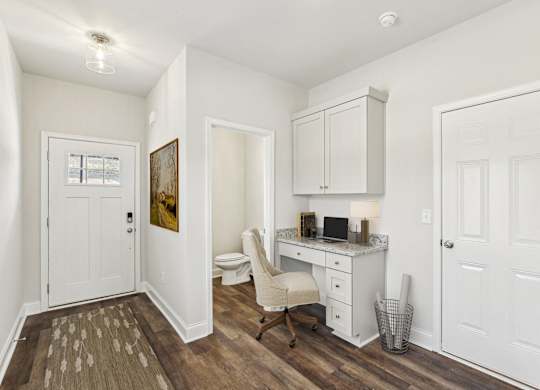 a room with a desk and a chair and a toilet