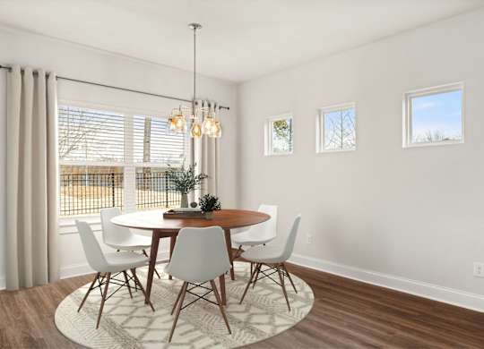 A dining room with a round table and chairs.
