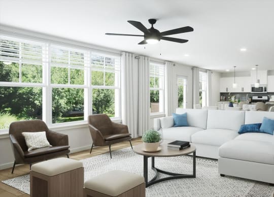 a living room with white furniture and a ceiling fan