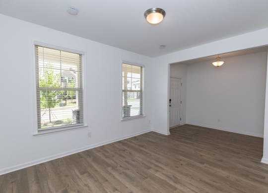 an empty living room with white walls and wood floors