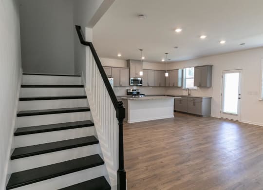 a view of a living room with a staircase and a kitchen