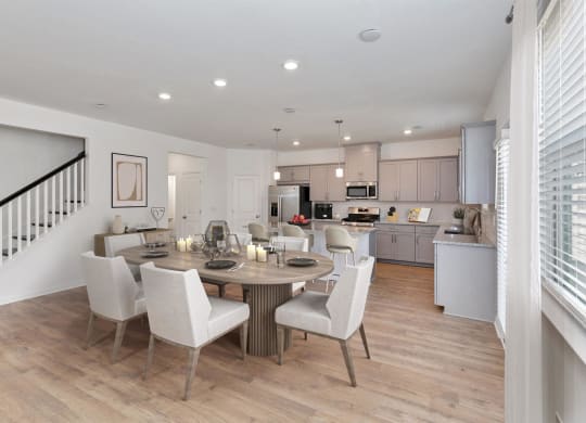 a dining room with a table and chairs in front of a kitchen