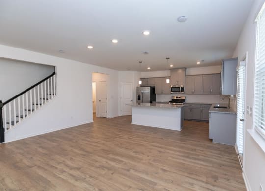 a living room with a kitchen and a staircase