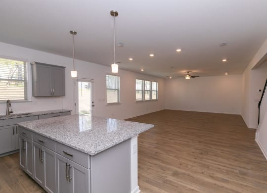 an open kitchen and living room with a counter top island