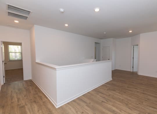 an empty living room with white walls and wood flooring