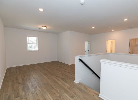 a newly renovated living room with white walls and wood floors
