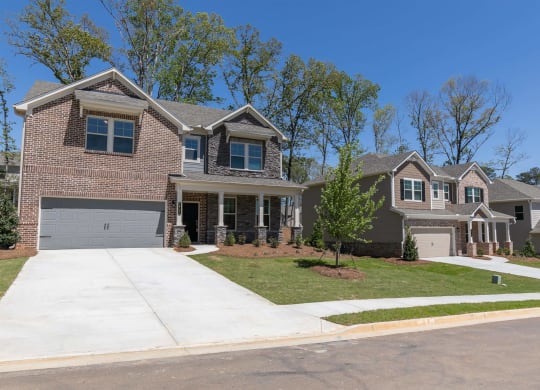 a house with a driveway and a lawn in front of it