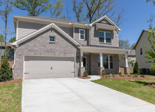 a house with a driveway and a garage door in front of it