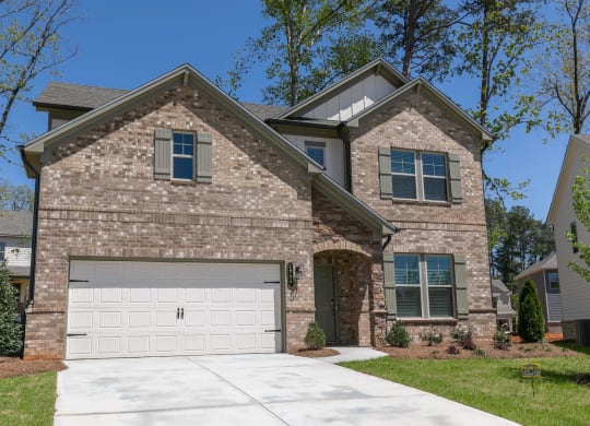 a tan brick house with a white garage door