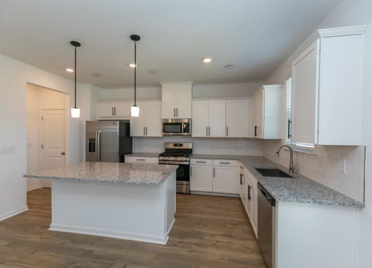a kitchen with white cabinets and granite counter tops