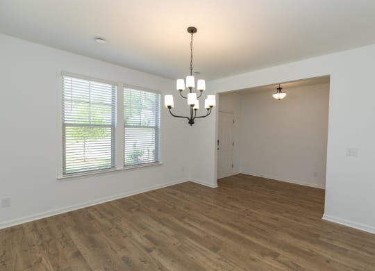 a living room with a large window and a chandelier