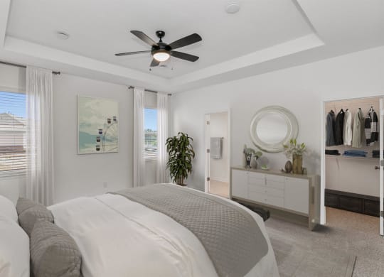 a bedroom with a bed and a ceiling fan