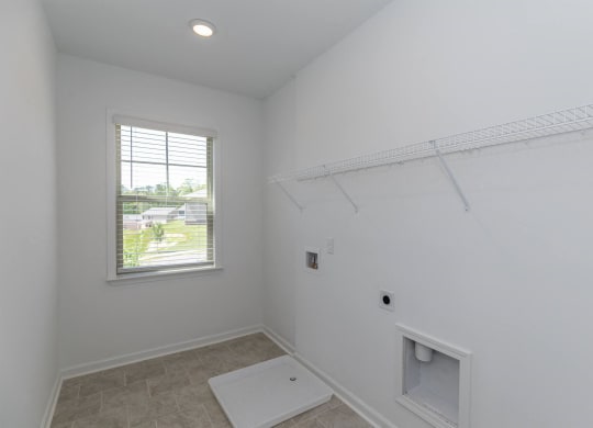 an empty room with a window and a white wall