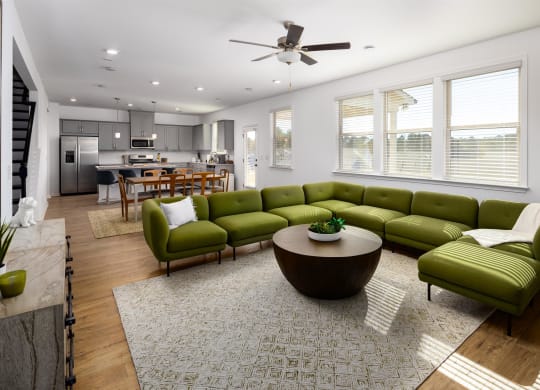 a living room with green couches and a round coffee table