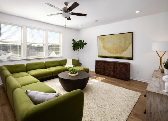 a living room with green couches and a round coffee table