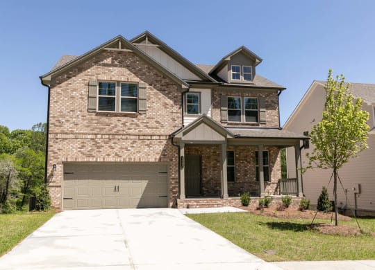 a house with a driveway and a garage door in front of it