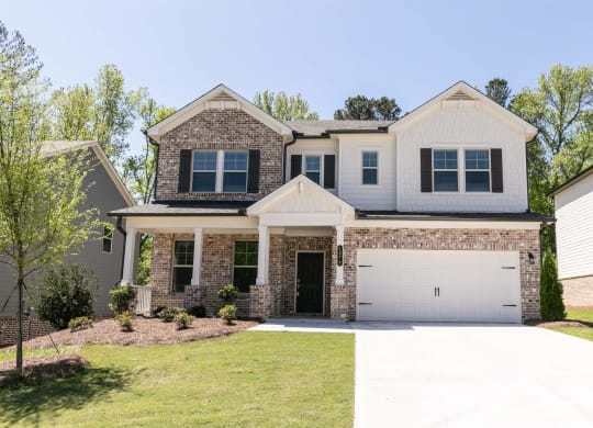 a house with a white garage door in front of a lawn