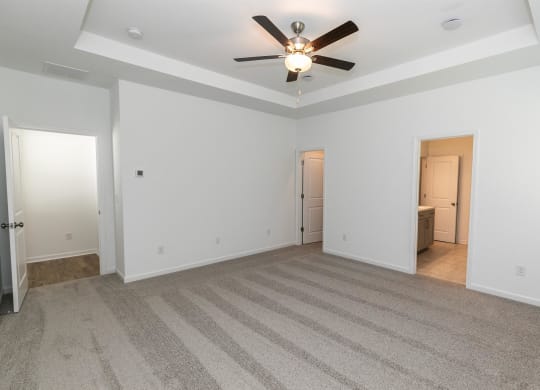 the living room of an empty house with a ceiling fan