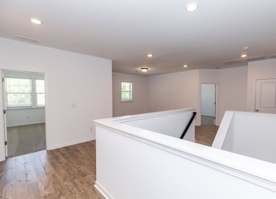 a newly renovated living room and kitchen with white walls and wood floors