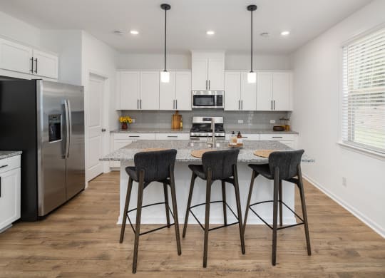 a kitchen with a island with three stools