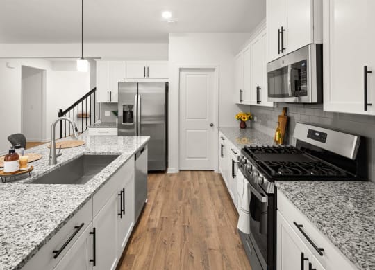 a kitchen with marble counter tops and white cabinets