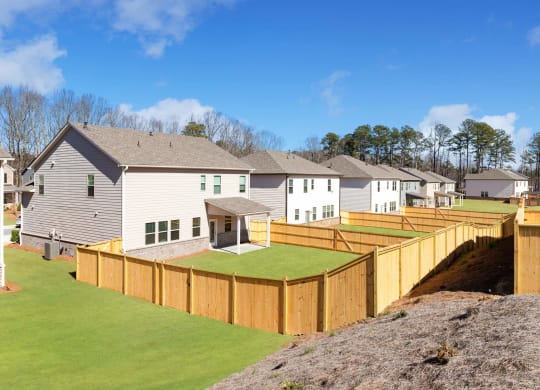 a wooden fence around a yard in front of houses
