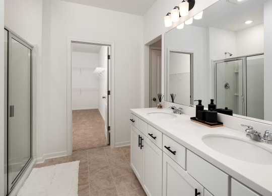 a white bathroom with two sinks and a shower
