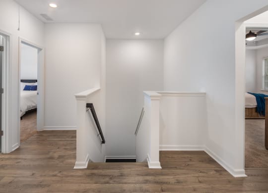 a small white wall with a staircase in a room with a bedroom