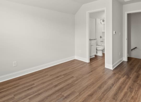 a living room with a hard wood floor and white walls