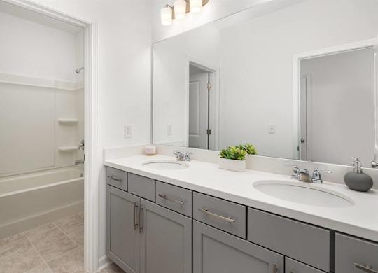 A bathroom with a white countertop and a grey cabinet.