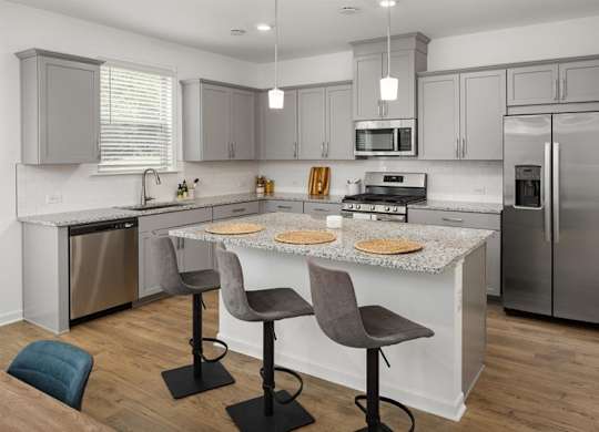 View of the kitchen and entry hallway. Offering bar seating, plenty of cabinet space and granite countertops.