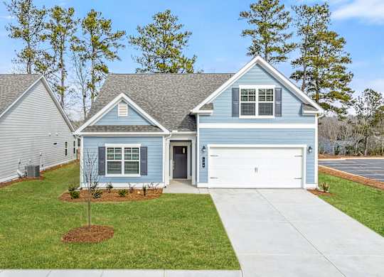 A house with a grey roof and a blue house in front.