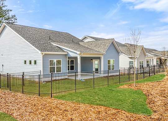 A white house with a black fence in front of it.