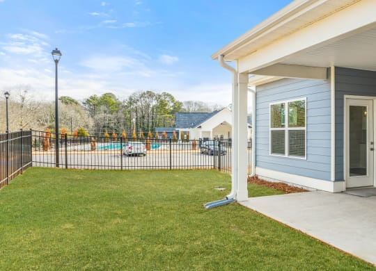 the entrance to a house with a yard and a fence