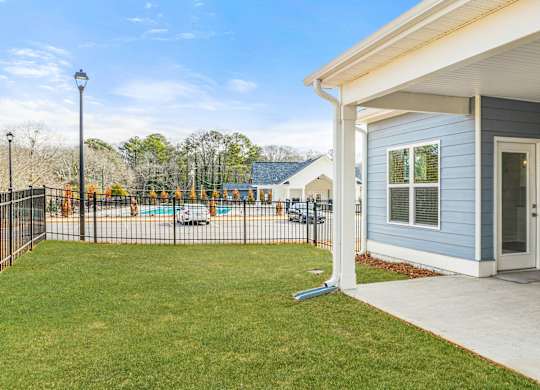 A blue house with a white porch and a black fence.