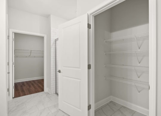 A white kitchen pantry with a door open.