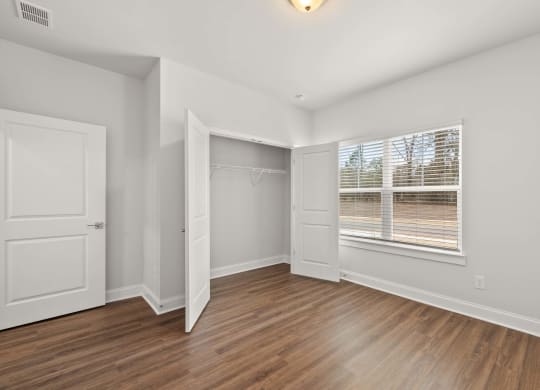 a room with white walls and a wooden floor and a glass shower
