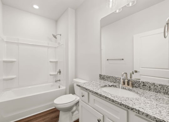 A white bathroom with a toilet, sink, and bathtub.