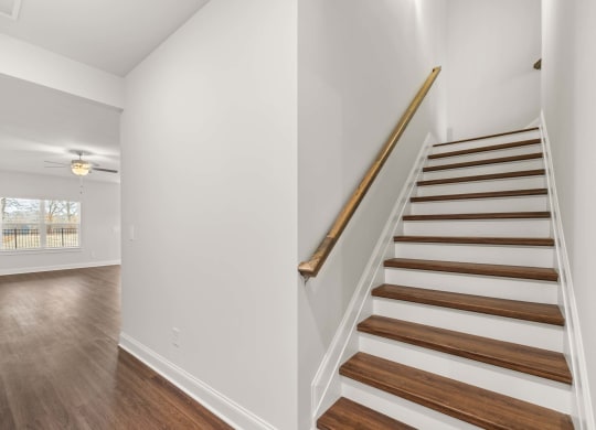 a staircase in a home with white walls and wood floors