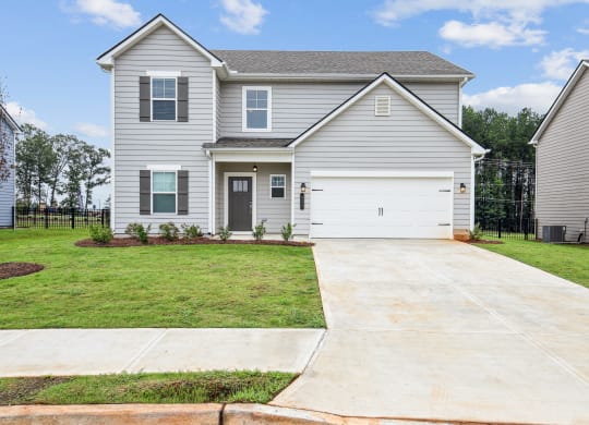 a white house with a driveway and a lawn