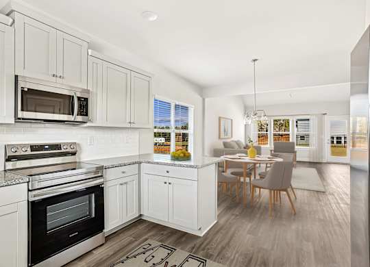 Full view of the kitchen and adjoining dining area, featuring a table and chairs for comfortable dining.