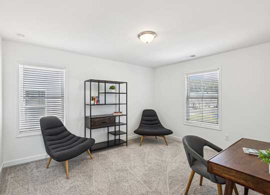 two chairs and a table in a room with two windows