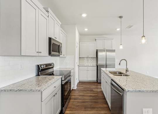 a white kitchen with marble counter tops and white cabinets
