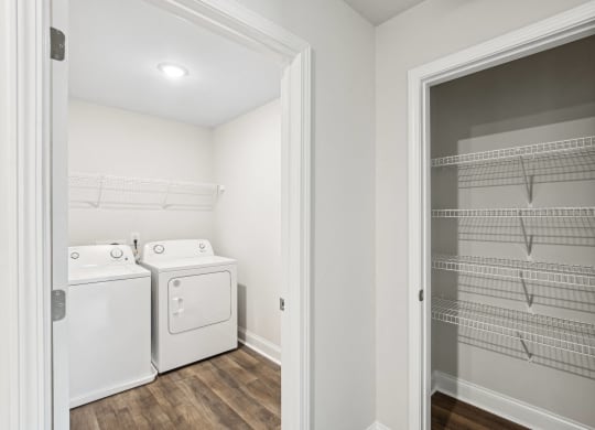 a laundry room with a washer and dryer and a closet with shelves