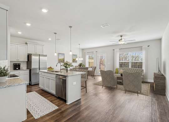 the gathering room and kitchen of a new home with an open floor plan
