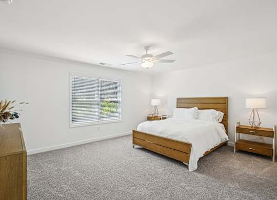 a white bedroom with a bed and a ceiling fan