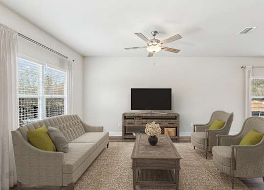 a living room with a couch and chairs and a tv