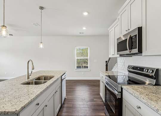 a kitchen with granite counter tops and white cabinets